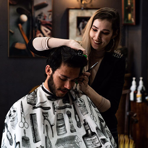 Woman giving man fresh haircut